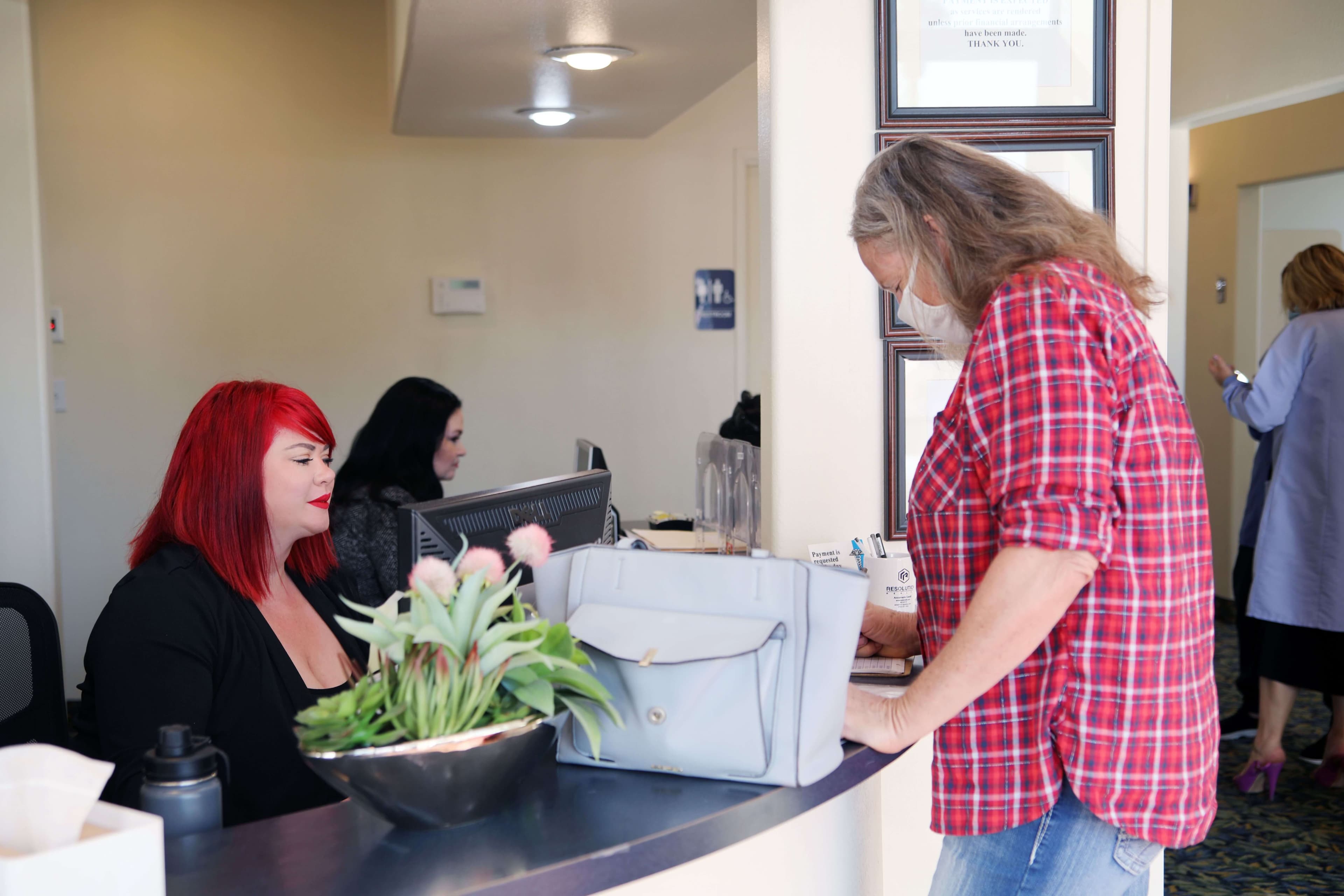 Two people are talking, happy customer and office representative